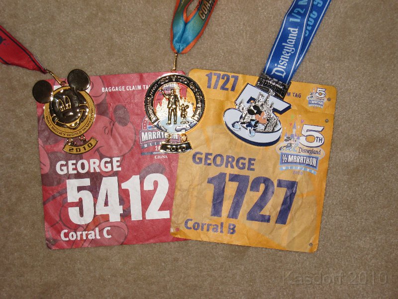 Disneyland 2010 HM Race 0750.JPG - The set of Disney medals and bibs. On left, Disneyworld Full MarathonOn right, Disneyland Half MarathonCenter, Coast to Coast Challenge Medal.